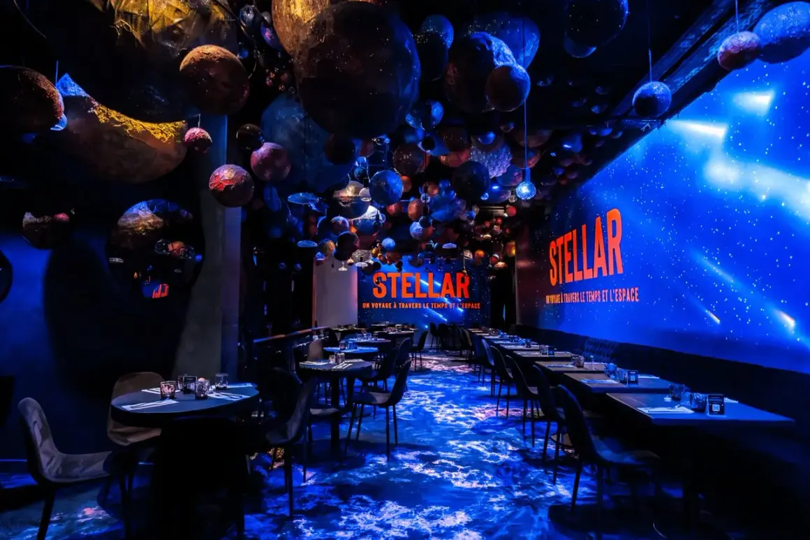 Décoration de restaurant "STELLAR" avec des planètes suspendues, évoquant un voyage **éphemère stellaire**. L'ambiance est cosmique et immersive.