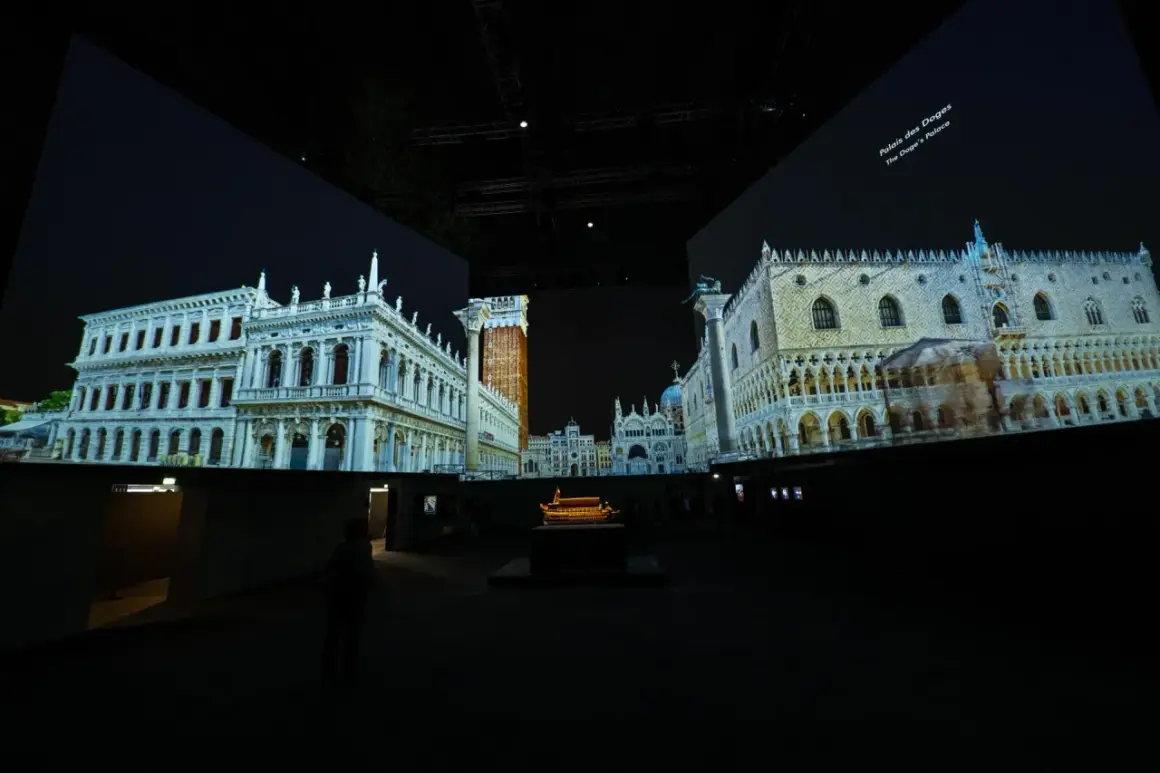 Dans un grand palais immersif, des projections vidéo recréent Venise. On y voit le Palais des Doges et d'autres édifices majestueux.