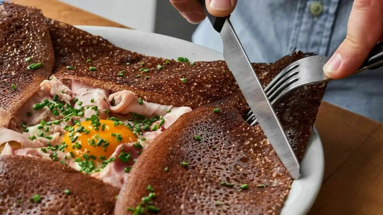 Une galette garnie d'&oelig;uf, jambon et ciboulette, coup&eacute;e au couteau et &agrave; la fourchette. Un d&eacute;lice qui promet les best crepes in Paris.