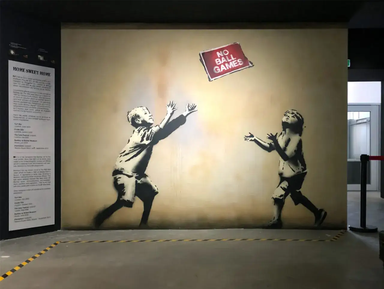 Œuvre de Banksy dans un musée parisien : deux enfants jouent, un panneau