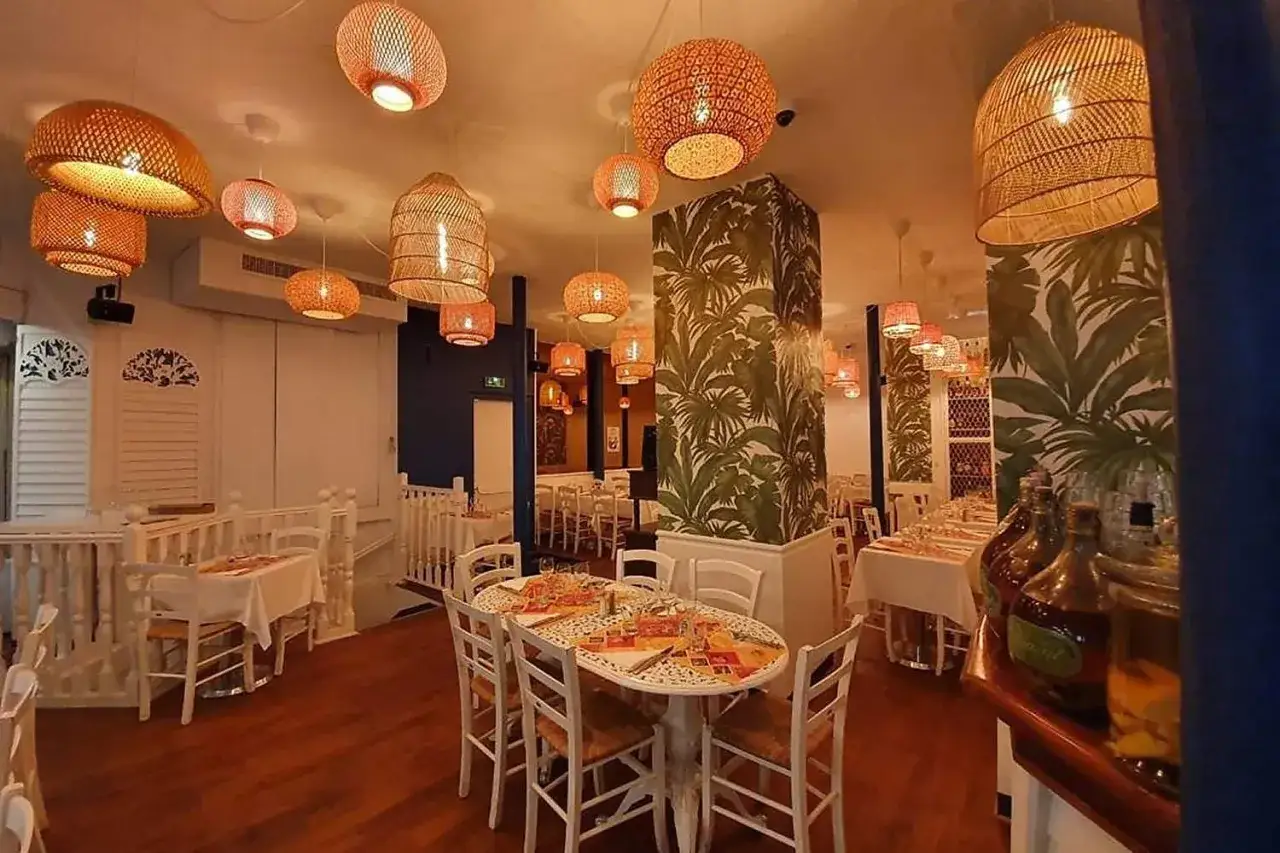 Ambiance tropicale dans ce restaurant antillais, avec ses suspensions en rotin et son papier peint luxuriant.