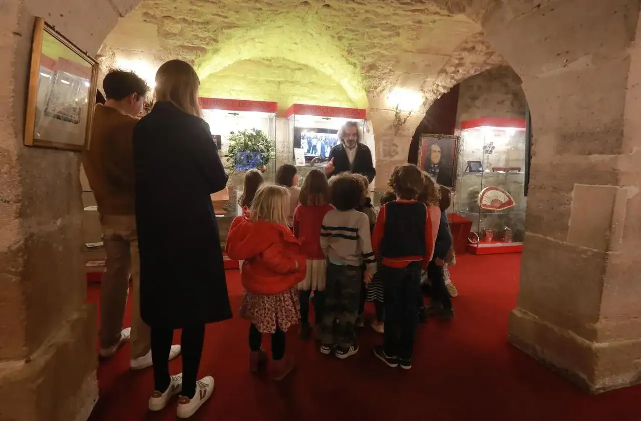 Visite guid&eacute;e d'un groupe d'enfants dans un mus&eacute;e de la magie, d&eacute;couvrant des objets d'illusionnistes.