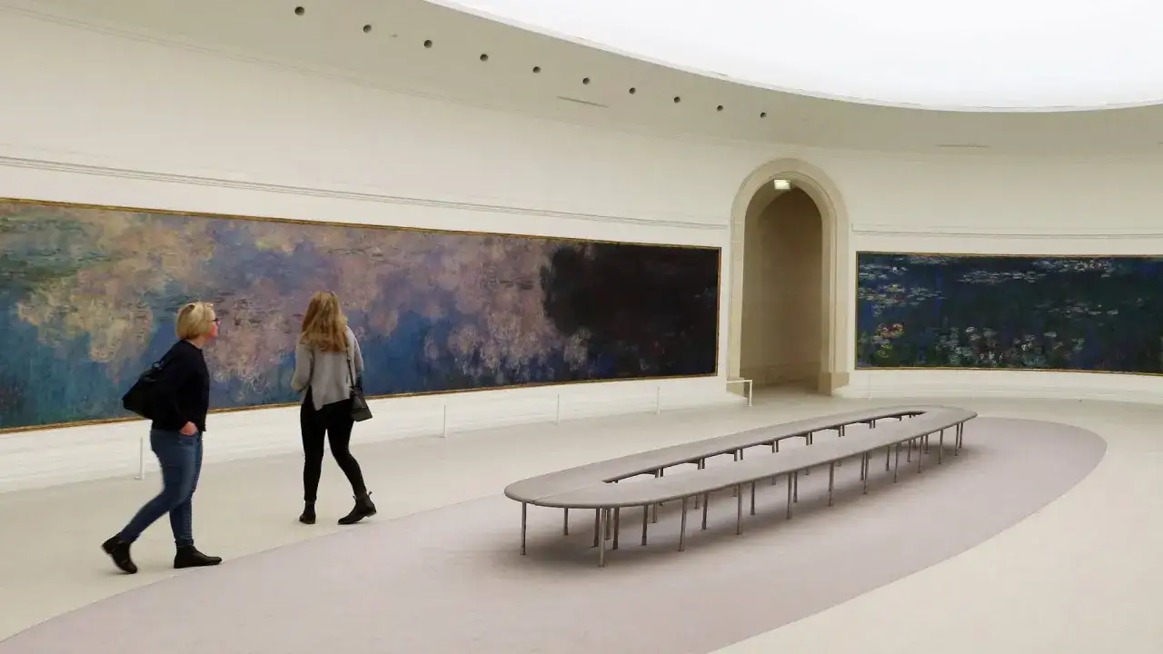 Deux visiteurs contemplent les Nymph&eacute;as au mus&eacute;e de l'Orangerie &agrave; Paris.