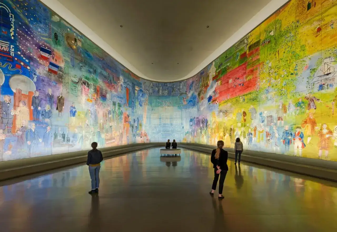 Des visiteurs contemplent une fresque color&eacute;e et foisonnante, une expo gratuite &agrave; Paris.