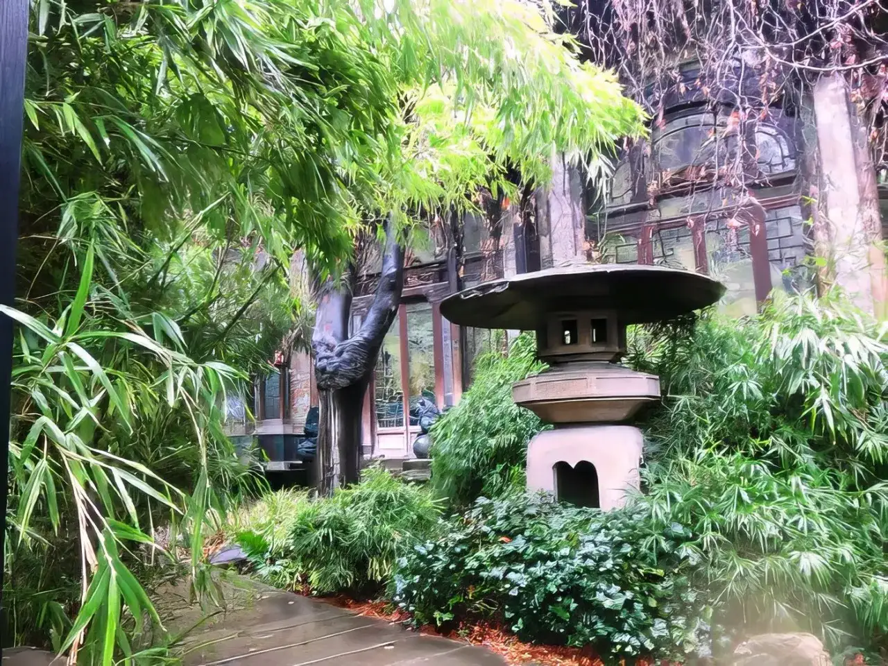 Un jardin luxuriant entoure une lanterne japonaise, &eacute;voquant la qui&eacute;tude d'une pagode parisienne.
