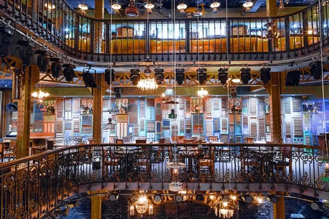 Intérieur de Pachamama Paris : ambiance unique avec murs décorés de volets colorés, balcons en fer forgé et éclairage tamisé. Un lieu idéal pour un avis mémorable.