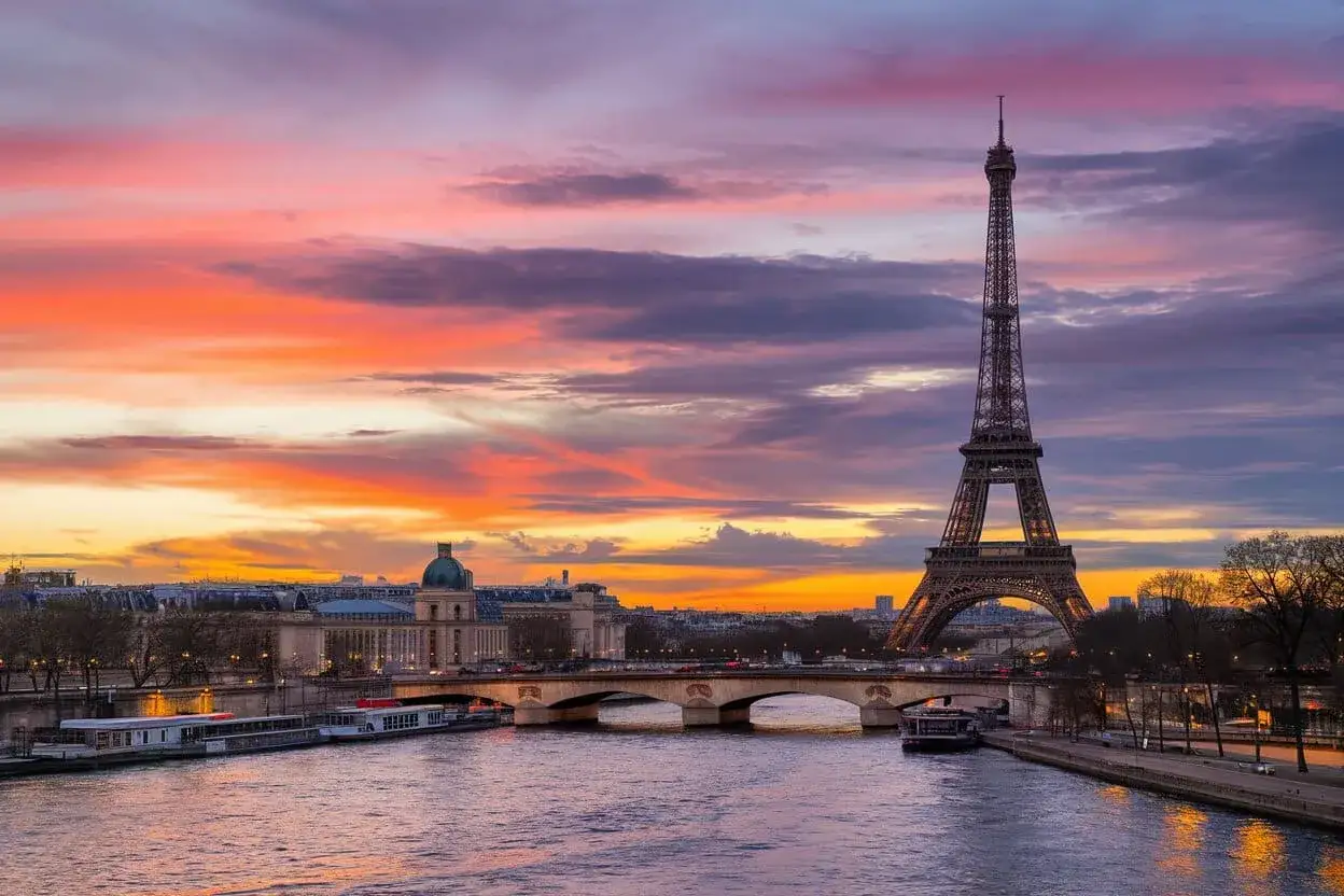 Coucher de soleil spectaculaire sur Paris, avec la Tour Eiffel dominant le ciel aux couleurs flamboyantes. Un spot photo inoubliable.