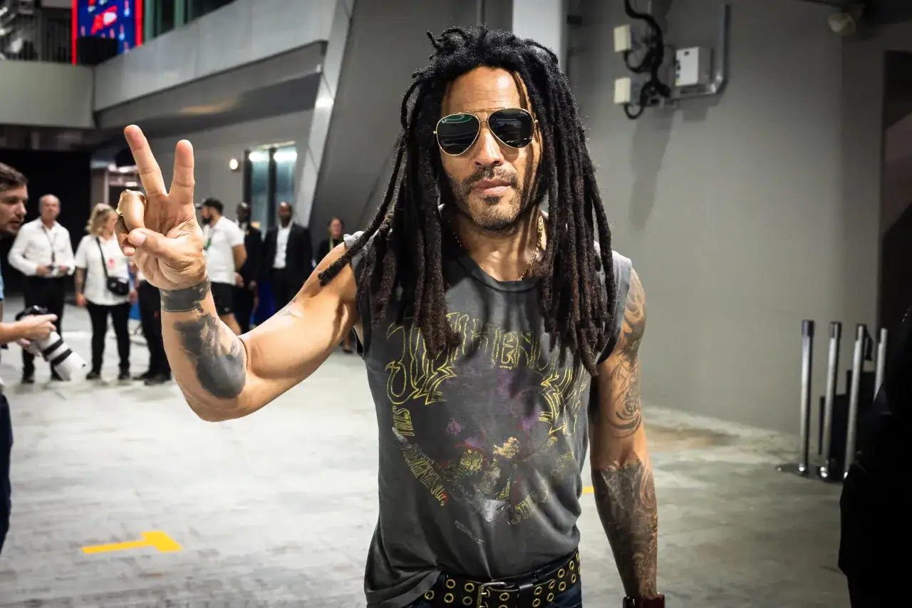 Lenny Kravitz, ic&ocirc;ne rock, fait un signe de paix &agrave; Paris, lunettes de soleil aviateur, dreadlocks, t-shirt vintage.