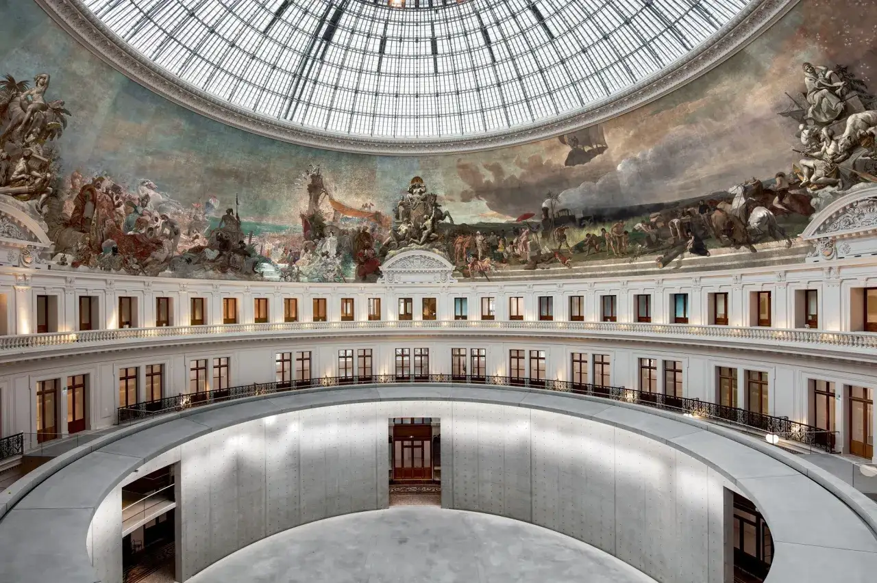 Int&eacute;rieur du mus&eacute;e de la Bourse, avec une fresque monumentale sous une coupole de verre et des balcons circulaires.