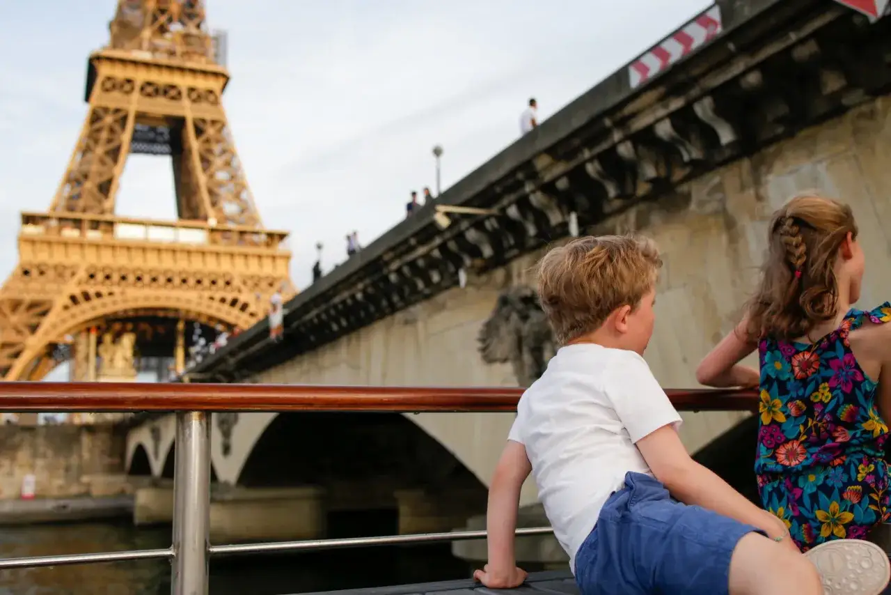 Enfants admirant la Tour Eiffel depuis un bateau, une belle id&eacute;e de choses &agrave; faire &agrave; Paris avec des enfants.
