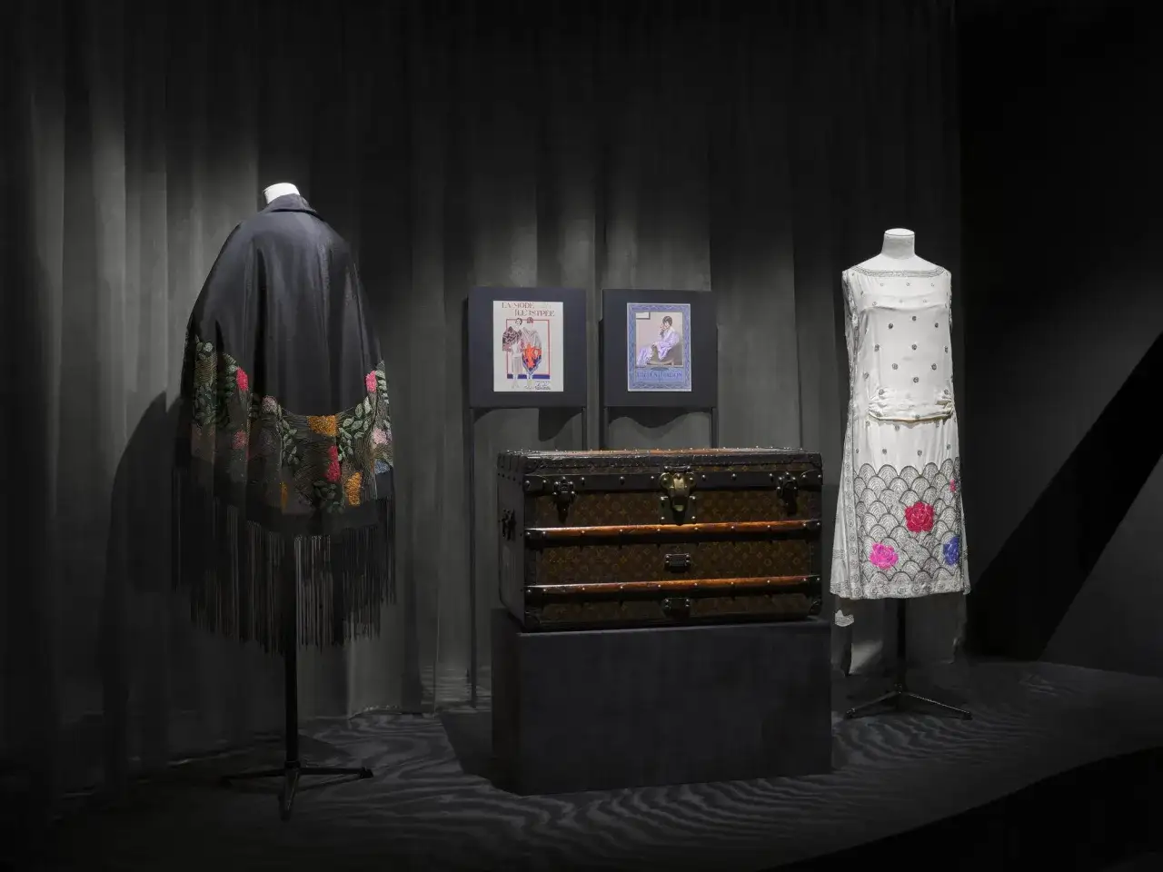 Un coffre Louis Vuitton, une cape brod&eacute;e et une robe vintage &eacute;voquent un r&ecirc;ve de mode.