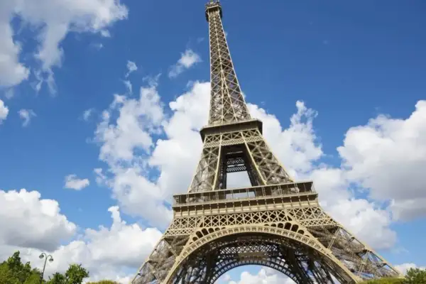 La Tour Eiffel se dresse fièrement sous un ciel bleu parsemé de nuages. Idéal pour savoir que faire autour de la Tour Eiffel.