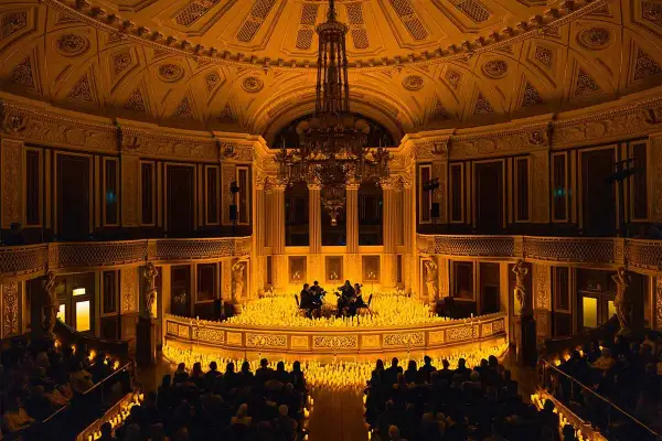 Concert de musique classique dans un théâtre parisien, illuminé par des milliers de bougies. Une scène magique de candlelight Paris.