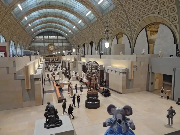 Vue panoramique du musée d'Orsay à Paris, avec ses vastes salles d'exposition, ses sculptures et ses visiteurs.