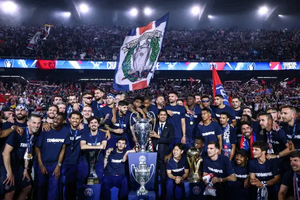 L'équipe célèbre sa victoire au Parc des Princes, soulevant des trophées sous les acclamations de la foule.