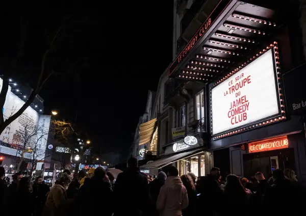 Une foule attend devant le Jamel Comedy Club à Paris pour une soirée de stand-up.