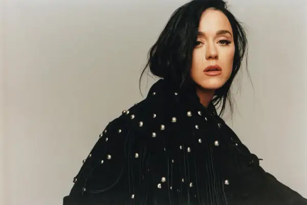 Katy Perry, vêtue d'une veste noire cloutée, pose avec intensité, évoquant le glamour de Paris.