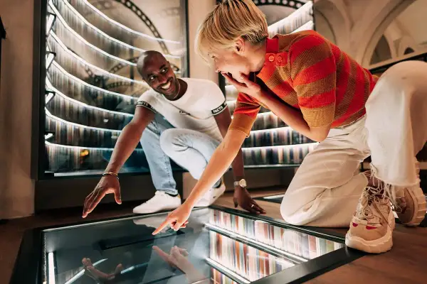 Un couple s'émerveille devant une installation interactive dans un musée des paradoxes.