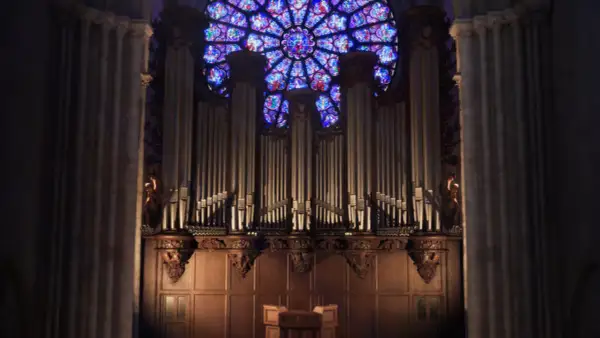 L'orgue majestueux de Notre-Dame, une vision éternelle, se dresse sous la rosace aux vitraux éclatants.