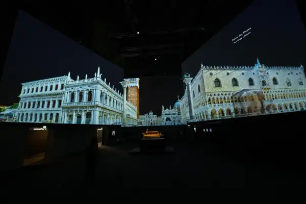 Dans un grand palais immersif, des projections vidéo recréent Venise. On y voit le Palais des Doges et d'autres édifices majestueux.
