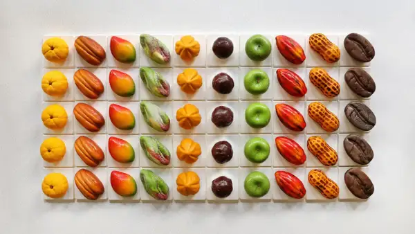 Assortiment de chocolats aux formes fruitées et originales, rappelant l'univers de Cédric Grolet. Des mangues, citrons, cacahués, fèves de cacao et autres délices.